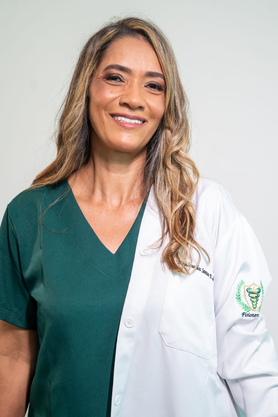 Madalena Souza usando jaleco branco sobre blusa verde